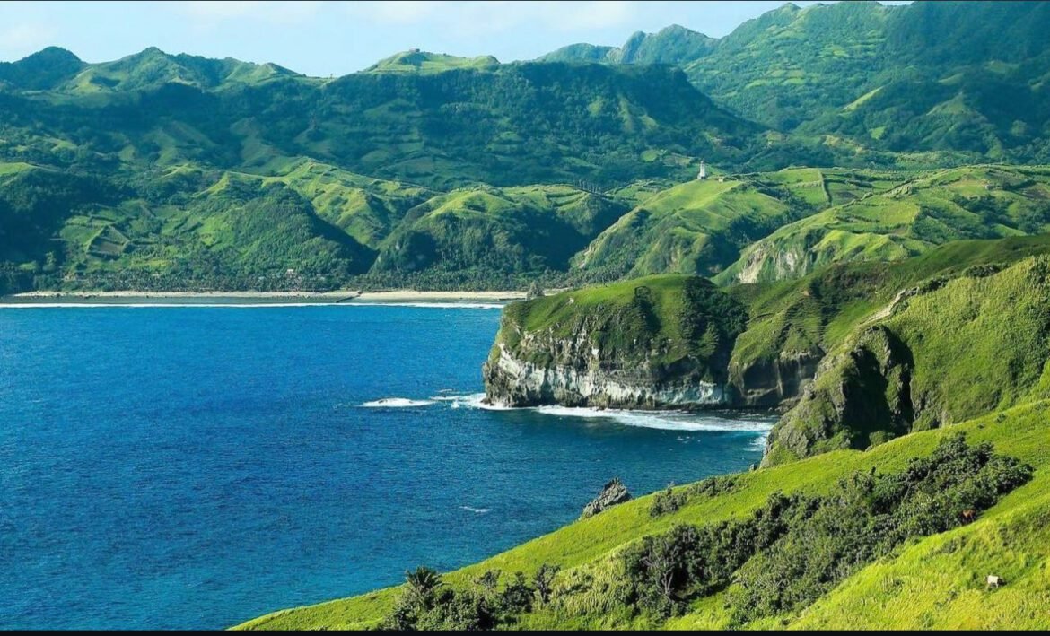 a green hills and blue water